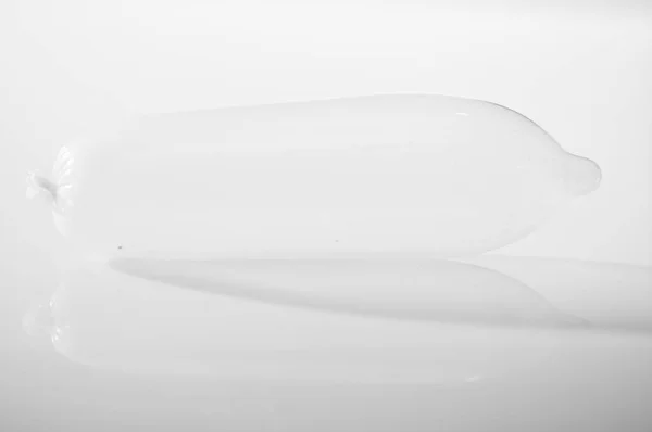 クローズ アップ透明なコンドームが白色、スタジオの背景、性的な安全コンセプトの上に横たわる空気で満たされました。, — ストック写真