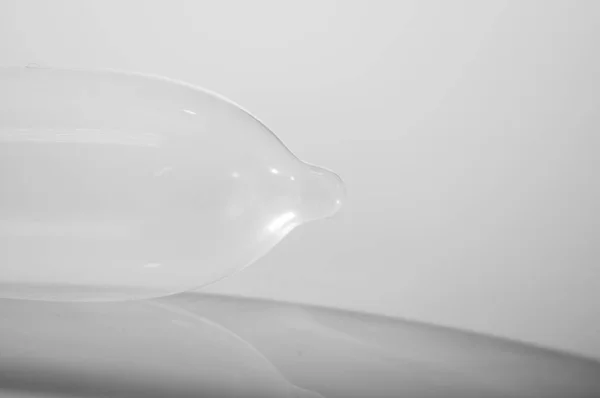 Primer plano condón transparente lleno de aire acostado en la superficie blanca, fondo de estudio, concepto de seguridad sexual , — Foto de Stock