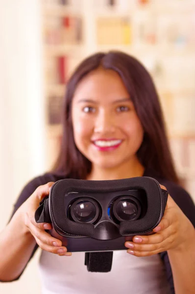 Młoda brunetka kobieta trzyma się okulary wirtualnej rzeczywistości Wyświetlono do aparatu, koncepcja vr — Zdjęcie stockowe