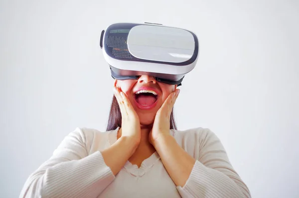 Mujer morena joven con gafas de realidad virtual experimentando la tecnología del futuro, interactuando y sonriendo mientras juega, fondo de estudio, concepto vr —  Fotos de Stock