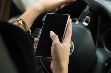 Portre siyah iç arka plan, kadın sürücü kavram smartphone ve direksiyon tutan el araç içinde