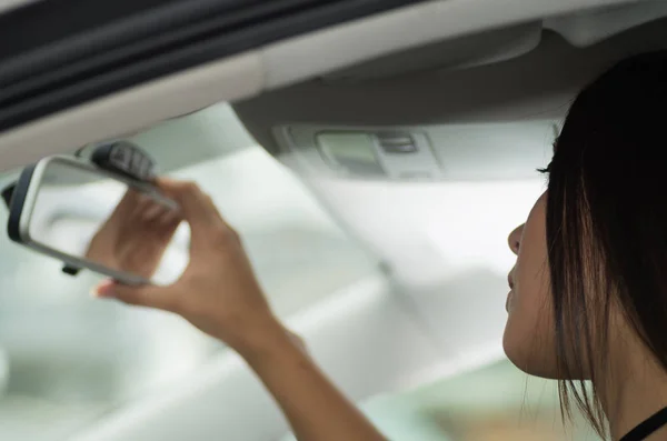 Nahaufnahme junge Frau sitzt im Auto Verstellspiegel, aus Sicht des Profilwinkels, Fahrerin Konzept — Stockfoto
