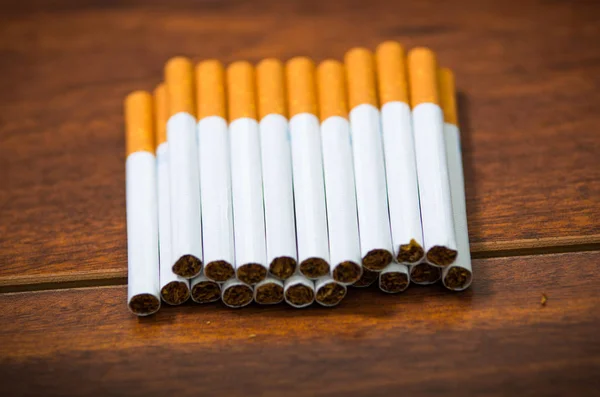 Stack of many cigarettes placed on wooden surface, as seen from above, artistic anti smoking concept — Stock Photo, Image