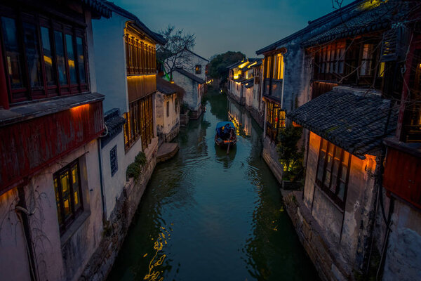 SHANGHAI, CHINA: Beautiful evening light creates magic mood inside Zhouzhuang water town, ancient city district with channels and old buildings, charming popular tourist area