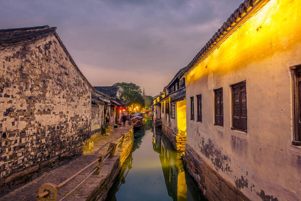 SHANGHAI, CHINA: Beautiful evening light creates magic mood inside Zhouzhuang water town, ancient city district with channels and old buildings, charming popular tourist area