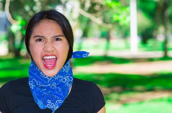 Jonge brunette vrouw draagt blauwe bandana om nek, interactie buitenshuis voor camera, activist protest concept — Stockfoto