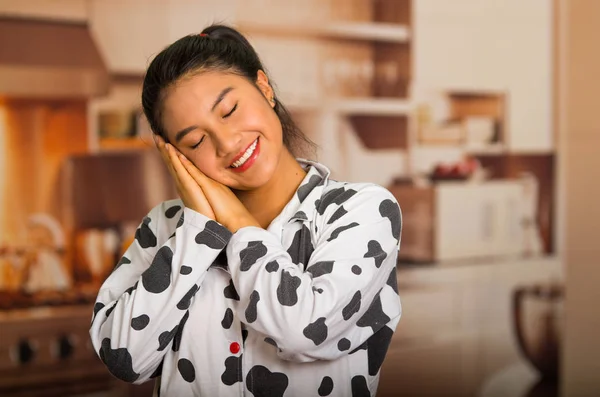 Jonge brunette vrouw poseren in pyjama's, interactie met ogen gesloten met behulp van handen en lacht om de camera te slapen — Stockfoto