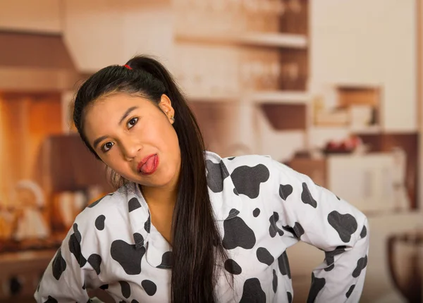 Young brunette woman posing in pyjamas, interacting with camera showing tongue and smiling — Stock Photo, Image