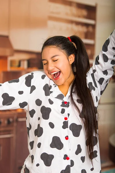 Young brunette woman posing in pyjamas, interacting with camera by stretching and yawning — Stock Photo, Image