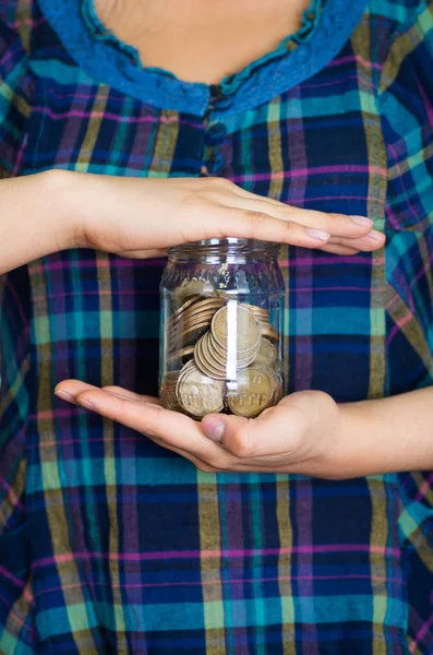 Woman facing camera, holding glass jar with coins inside — Stock Photo, Image