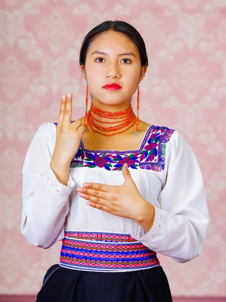 Młoda kobieta sobie tradycyjny strój Andyjskiej, stoi aparat robi słowo języka migowego dla syna — Zdjęcie stockowe