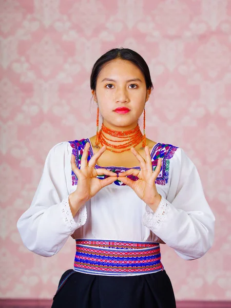 Mujer joven con vestido andino tradicional, frente a la cámara haciendo palabra de lenguaje de señas para importante — Foto de Stock