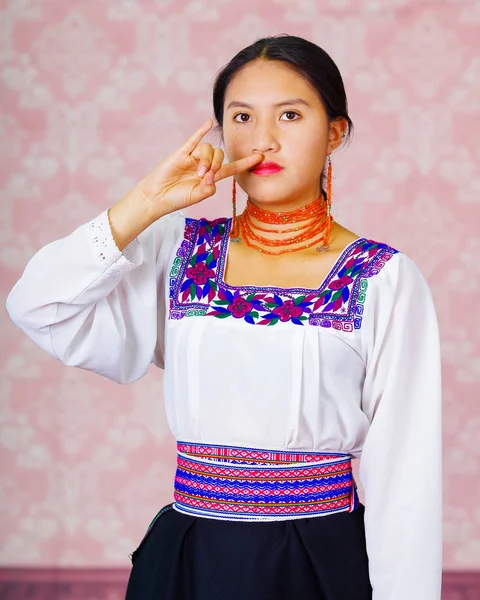 Jonge vrouw dragen traditionele Andes jurk, geconfronteerd met camera doen gebarentaal word voor jongen — Stockfoto