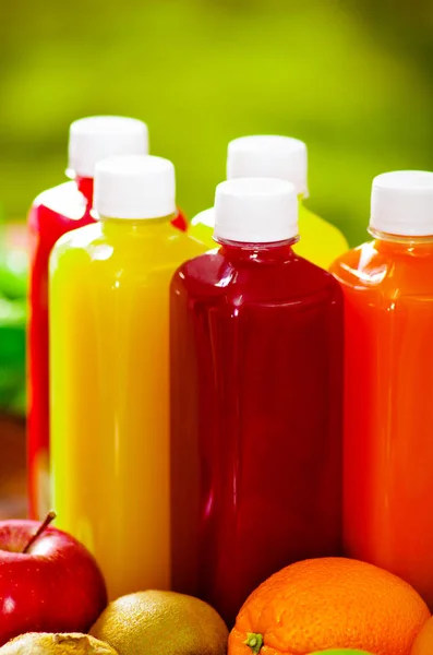 Botellas de delicioso jugo orgánico rodeado de frutas y verduras, hermosos colores, concepto de estilo de vida saludable —  Fotos de Stock