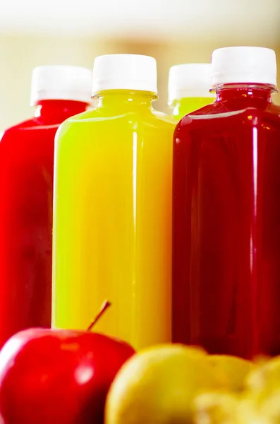 Bottiglie di delizioso succo biologico circondato da frutta e verdura, bei colori, concetto di stile di vita sano — Foto Stock