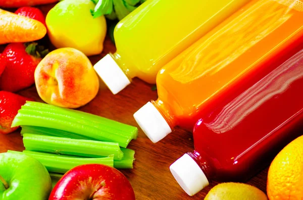 Lahví lahodné organické šťávy ležící na stole udržované ovoce a vegetariáni, krásné barvy, koncept zdravého životního stylu — Stock fotografie