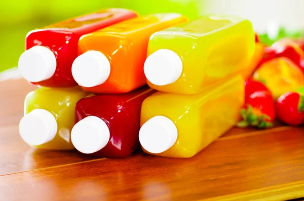 Fechar em cima de garrafas de suco deitado empilhado, cores bonitas e conceito saudável — Fotografia de Stock