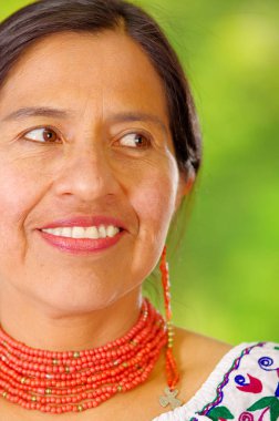 Mutlu Bahçe arka kamera için poz Closeup güzel İspanyol kadın boyun, eşleşen kırmızı kolye ve kulak, renkli dekorasyon ile geleneksel and beyaz bluz giyiyor