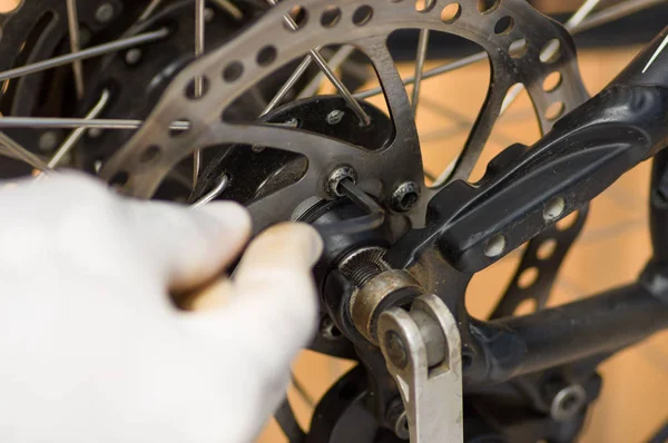 Vértes kéz mechanikus alkatrészek-kerék küllői mellett dolgozik — Stock Fotó