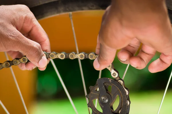 Closeup hand bezig met mechanische onderdelen naast wiel spaken — Stockfoto