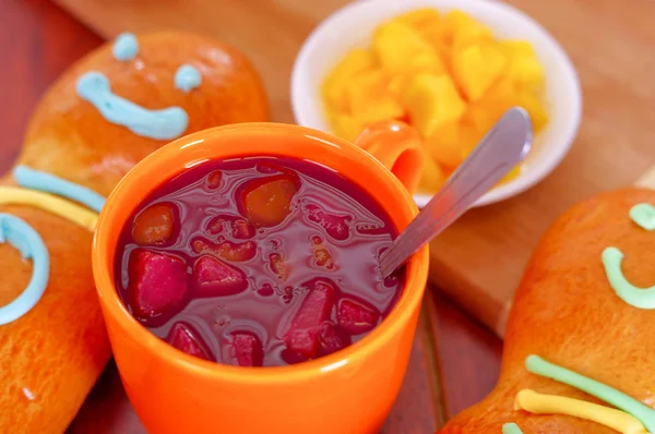 Elegant setup traditional tasty latin american guagua breads, colorful sugar decorations, orange cup with colada morada berry juice next to it, day of the dead concept — Stock Photo, Image