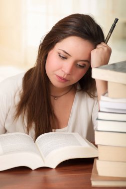 Kütüphanede kitap okuyarak uykuya yorgun öğrenci kız