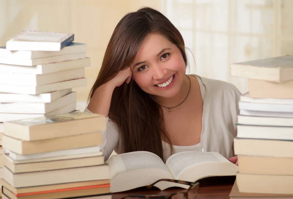 Portrait of clever student with open book reading it in college library smiling — Stock Photo, Image