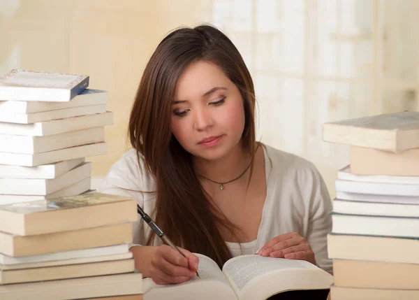 Estudante cansado menina escrever e adormecer com livros na biblioteca — Fotografia de Stock