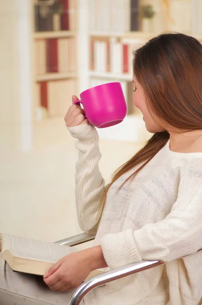 Bella ragazza che legge un libro godendo di una tazza di tè — Foto Stock