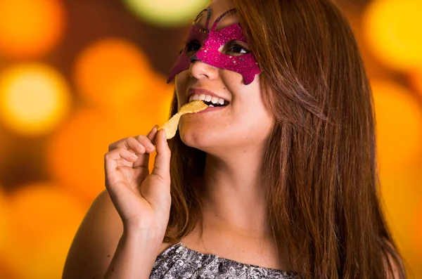 Mulher modelo de beleza usando máscara de carnaval rosa em fundo colorido — Fotografia de Stock