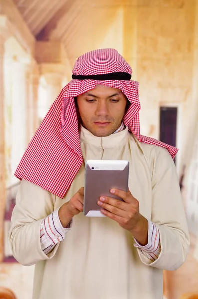 Carino giovane arabo uomo utilizzando la sua tavoletta — Foto Stock