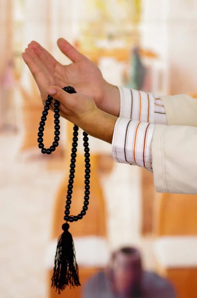 Arabo ragazzo pregando il suo dio e tenendo un masbaha — Foto Stock