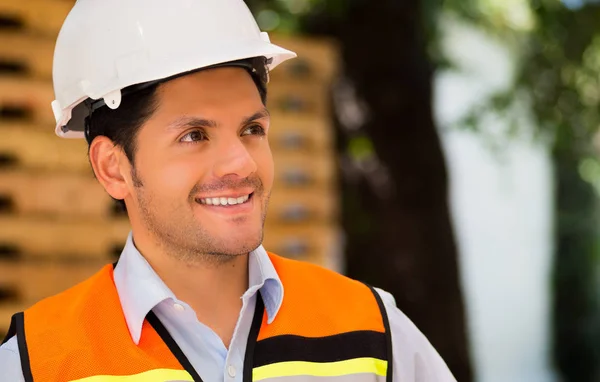 Handsome young engineer looking away at construction site — Stock Photo, Image