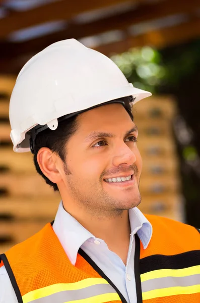 Engineer looking away while holding clipboard at construction site — Stock Photo, Image