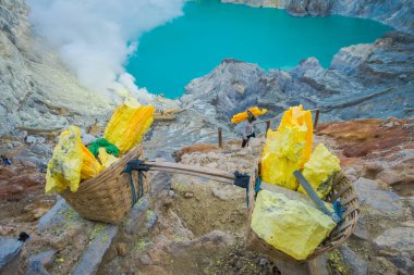 Kaweh Ijen'de, Endonezya: Sarı sülfür kayalar sepetleri, muhteşem volkanik krater Gölü arka plan, turistik cazibe hiking içinde