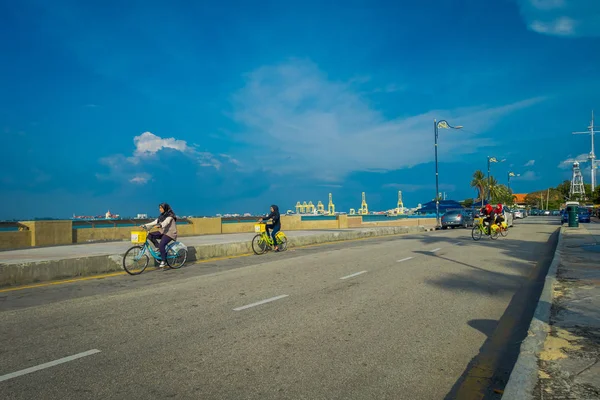 George Town, Malasia - 10 de marzo de 2017: Hermosa vista panorámica de mujeres musulmanas desconocidas montando bicicletas a lo largo de la explanada, una ubicación frente al mar en el corazón de la ciudad . — Foto de Stock