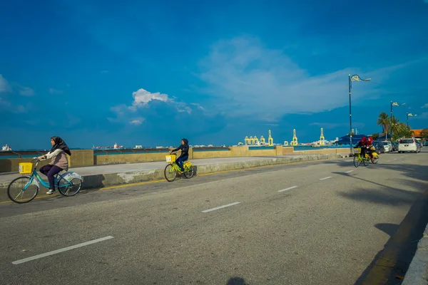 George Town, Malezya - 10 Şubat 2017: Bilinmeyen Müslüman kadınların sürme güzel doğal görünümü Esplanade şehrin kalbinde waterfront konuma bisikletler. — Stok fotoğraf