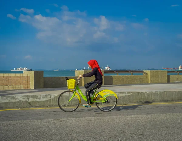 Джордж Таун, Малайзия - 10 марта 2017 года: Прекрасный живописный вид на неизвестных мусульманских женщин, катающихся на велосипедах вдоль набережной Эспланады в центре города . — стоковое фото