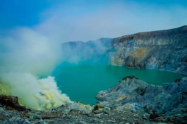 KAWEH IJEN, INDONÉSIA: Bela visão geral da mina de enxofre com mineiros trabalhando ao lado do lago cratera vulcânica, natureza espetacular — Fotografia de Stock