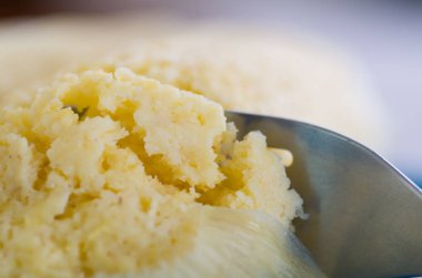 A yakın çekim üzerinden humita bir parça üzerinde mavi bir tabak Dilimleme metalik çatal