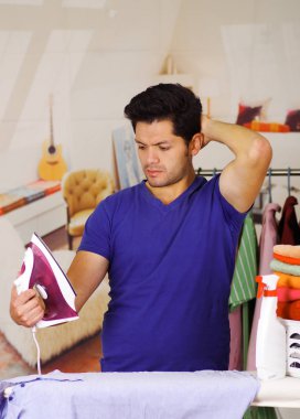 Bir demir mavi tişört kullanarak elinde tutan yakışıklı genç