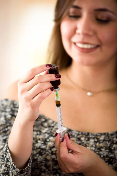 Schöne junge Frau mit Spritze bereitet die Substanz zur Injektion vor — Stockfoto
