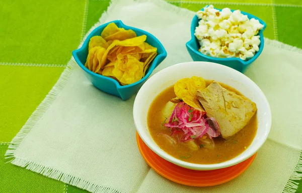 Delicioso estofado de pescado encebollado de Ecuador comida tradicional nacional primer plano, con palomitas de maíz y algunos chifles de plátanos —  Fotos de Stock