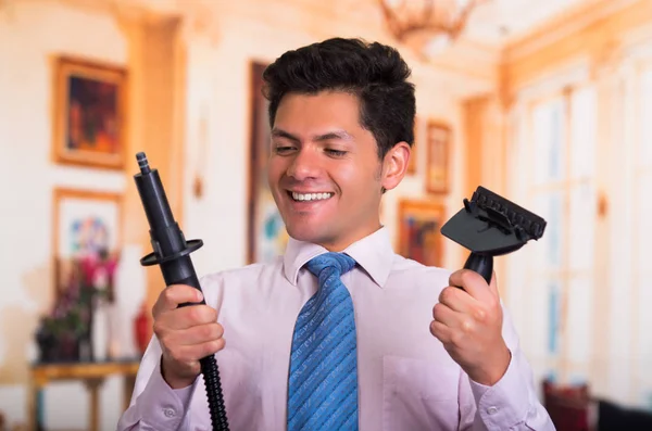 Hombre joven guapo en casa la fijación de una aspiradora —  Fotos de Stock