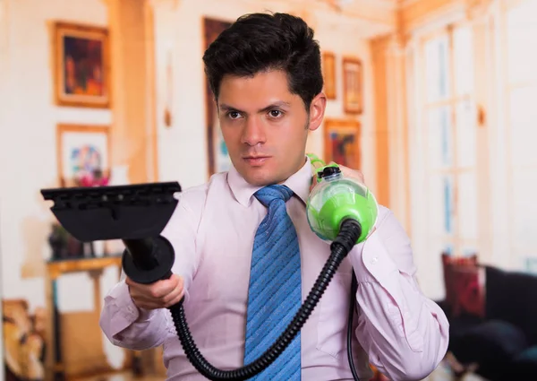 Handsome young Man cleaning home with vacuum cleaner in his shoulder — Stock Photo, Image