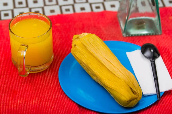 Un petit déjeuner rapide mais très nutritif contient un verre de jus d'orange et d'humita servi sur un plat bleu — Photo