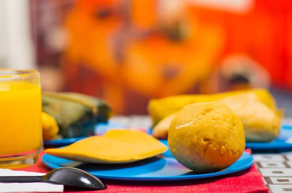 Un petit déjeuner énergique contient du jus d'orange, de l'empanada et du bolon servis sur une assiette bleue, concept alimentaire andin traditionnel — Photo