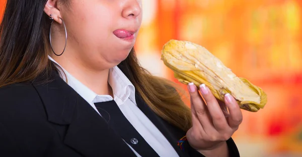Wspaniały ładna kobieta ma zamiar zjeść pyszne bolon w ręku, tradycyjnej koncepcji kuchni Andyjskiej — Zdjęcie stockowe