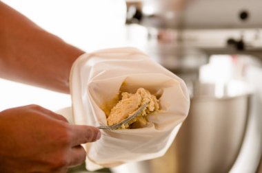 Ekmek man Ekle bazı buttercream bir boru çanta içinde