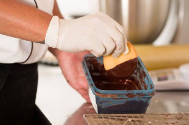 Fırın adam ahşap masa üzerine çikolata ile lezzetli taze vanilya kurabiye hazırlama